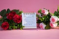 Desk calendar for February 2024 on a pink background with roses Royalty Free Stock Photo