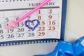 Desk calendar, pink pencil. 14 circled in red in the shape of a heart. Have a gift box