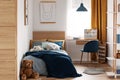 Desk, chair and single bed with blue bedding in cozy bedroom interior for children Royalty Free Stock Photo