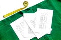 Desk of clothing designer. Green textile and pattern of clothing on white background top view