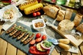 Desk with electric grill, grilled sausages, bread and camembert Royalty Free Stock Photo