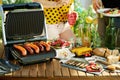 Desk with electric grill and grilled sausages Royalty Free Stock Photo