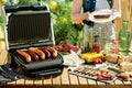 Desk with electric grill and grilled sausages Royalty Free Stock Photo