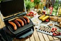 Desk with electric grill and grilled sausages Royalty Free Stock Photo