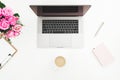 Desk with female workspace - laptop, pink roses, coffee mug, pink diary on white background. Flat lay. Top view. Royalty Free Stock Photo