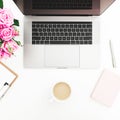 Desk with female workspace with laptop, pink roses, coffee mug, pink diary on white background. Flat lay. Top view. Fashion or fre Royalty Free Stock Photo