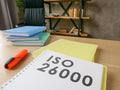 Desk with guide about iso 26000 on it. Royalty Free Stock Photo