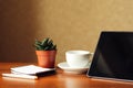 Desk at home office. Black tablet, indoor flower and notepad on a wooden table. Concept - work at home, freelancer Royalty Free Stock Photo