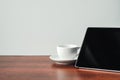 Desk at home office. Black tablet, white mug on a wooden table. Concept - work at home, freelancer. Copy space, minimal Royalty Free Stock Photo