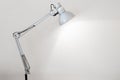 Desk lamp illuminating a white concrete wall