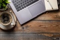 Desk with laptop, eye glasses, notepad, pen and a cup of coffee on a old wooden table. Top view with copy space. Flat lay. Dark ba