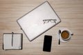 Desk with laptop, eyeglasses, notepad, smartphone, pen and a cup of tea on a wooden table. Top view with copy space. Flat lay - Royalty Free Stock Photo