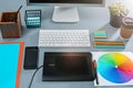 The gray desk with laptop, notepad with blank sheet, pot of flower, stylus and tablet for retouching Royalty Free Stock Photo