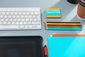 The gray desk with laptop, notepad with blank sheet, pot of flower, stylus and tablet for retouching Royalty Free Stock Photo