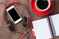 Desk with notepad, coffee, smartphone and headphones