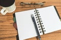 Desk with open notebook with blank pages, eye glasses, pen and a cup of coffee. Top view with copy space. Business still life Royalty Free Stock Photo