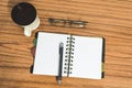 Desk with open notebook with blank pages, eye glasses, pen and a cup of coffee. Top view with copy space. Business still life Royalty Free Stock Photo