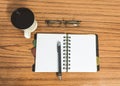 Desk with open notebook with blank pages, eye glasses, pen and a cup of coffee. Top view with copy space. Business still life Royalty Free Stock Photo