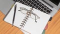 Desk with open notebook, pen, eye glasses, placed one another on office table. Top view with copy space. Business still life Royalty Free Stock Photo