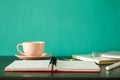 Desk with notebooks and coffee: front view