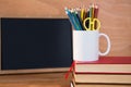 Desk organizer on stack of books against blackboard Royalty Free Stock Photo