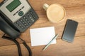 Desk phone, paper and a smart phone, on a table Royalty Free Stock Photo