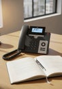 A desk setup features a modern office telephone with a digital display, indicating the Royalty Free Stock Photo
