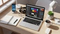 Desk setup with a laptop displaying image editing software accompanied Royalty Free Stock Photo