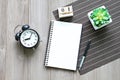 Desk table with open notebook paper, cube calendar and clock