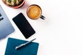 Desk, top view on a white background. Coffee, notebook, phone, plant Royalty Free Stock Photo