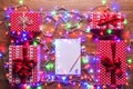 Desk view from above with empty letter to santa, presents and christmas lights, retro xmas concept