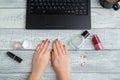 Desk. woman`s workplace. women`s hands,laptop,perfume and cosmetics. the view from the top. flat lay