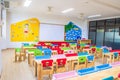 Desks, chairs and white board in the kindergarten classroom. And there are beautifully decorated knowledge boards Royalty Free Stock Photo