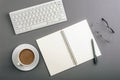 Desktop with blank notepad, keyboard, glasses and coffee cup on gray table. Top view, flat lay Royalty Free Stock Photo