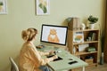 Desktop computer with fat ginger cat drawn by girl on screen Royalty Free Stock Photo