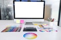 Desktop computer screen on white desk, Graphic designer and color swatch samples at workplace Royalty Free Stock Photo