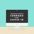 Desktop computer with the text: Temporarily closed due to Covid-19 in Spanish. Temporalmente cerrado por Covid-19. Coronavirus cri