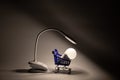 Desktop flexible LED lamp on the battery and LED light bulb in a supermarket basket in the dark on the table shines