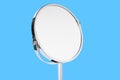 Desktop make up cosmetic mirror isolated on blue background. Home metal mirror close up isolated. Facial mirror.