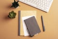 Desktop with notepad, pen, keyboard and succulent plants on beige table. Top view, flat lay Royalty Free Stock Photo