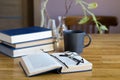 Desktop with an open book, stacks of books, a cup of coffee Royalty Free Stock Photo