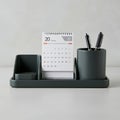 Desktop organizer with three compartments. A small calendar displaying \