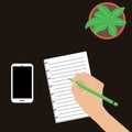 Desktop with a plant green. Holds a ballpoint pen female hand. Notepad with lines and a smartphone. Royalty Free Stock Photo