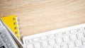 Desktop table with keyboard, calculator and yellow book on the brown wood table Royalty Free Stock Photo