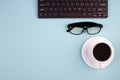 Desktop. Top view with copy space. Keyboard, glasses, cup of coffee on a light background