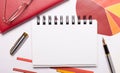 On the desktop is a white notebook with a place to insert text, a pen, burgundy and red charts, and gold-framed glasses. Business Royalty Free Stock Photo