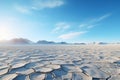 Desolate frozen desert under a pale sun. Crust of snow cracked in the wind. Clear bright sky snowy mountains on horizon Royalty Free Stock Photo