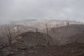 Desolate landscape of dead forest with burned and dry trees with view to Turrialba volcano on a cloudy day