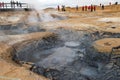 Geothermal field Namaskard, Iceland. People in desolate landscape with mud volcano and hot steam. Royalty Free Stock Photo