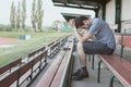 Despair and depressed man is sitting in stadium. Solitary and loneliness concept